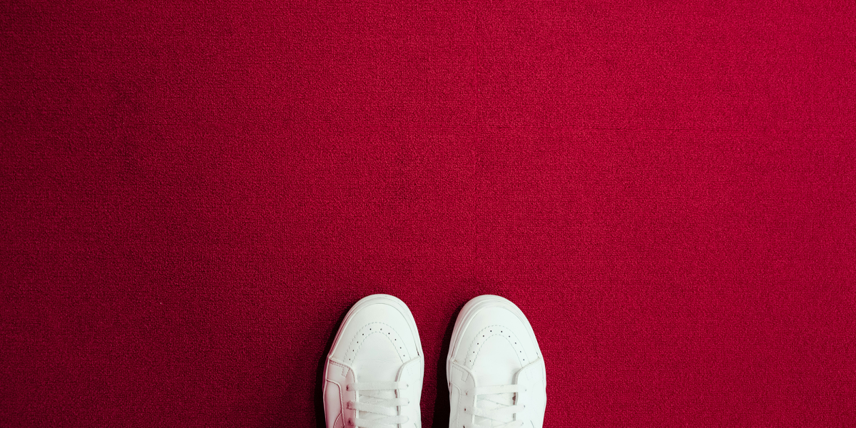 Trainers standing on a red background.