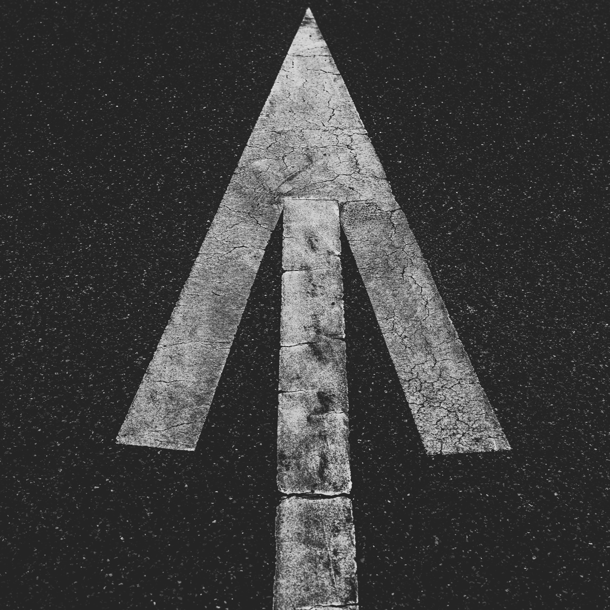 White arrowhead on a black background.