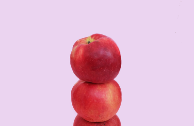 Three red apples balancing on top of one another.