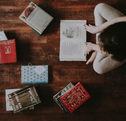 Person reading books on the floor